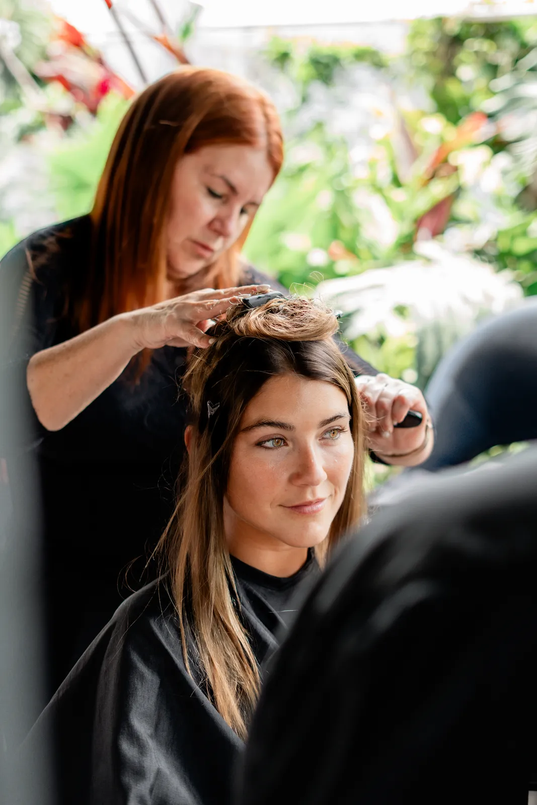 A stylist finishing a model's hair backstage