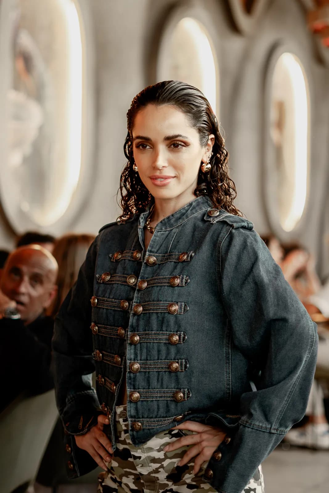 A model in a denim military jacket mid-walk