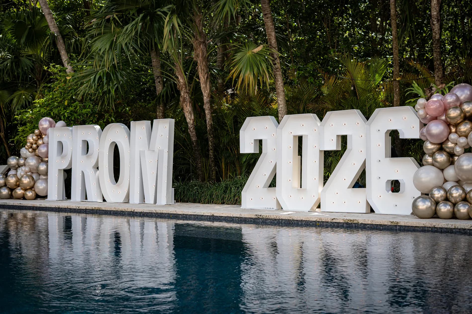 The installed PROM 2026 marquee letters by the pool