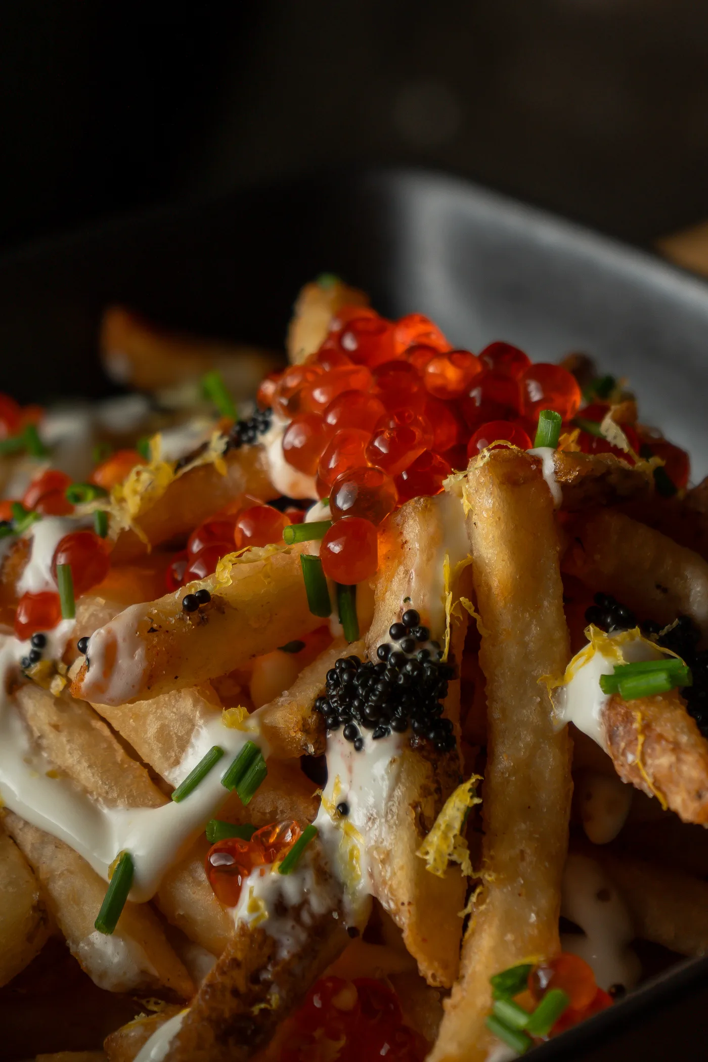 Loaded fries topped with salmon roe, caviar and chive cream