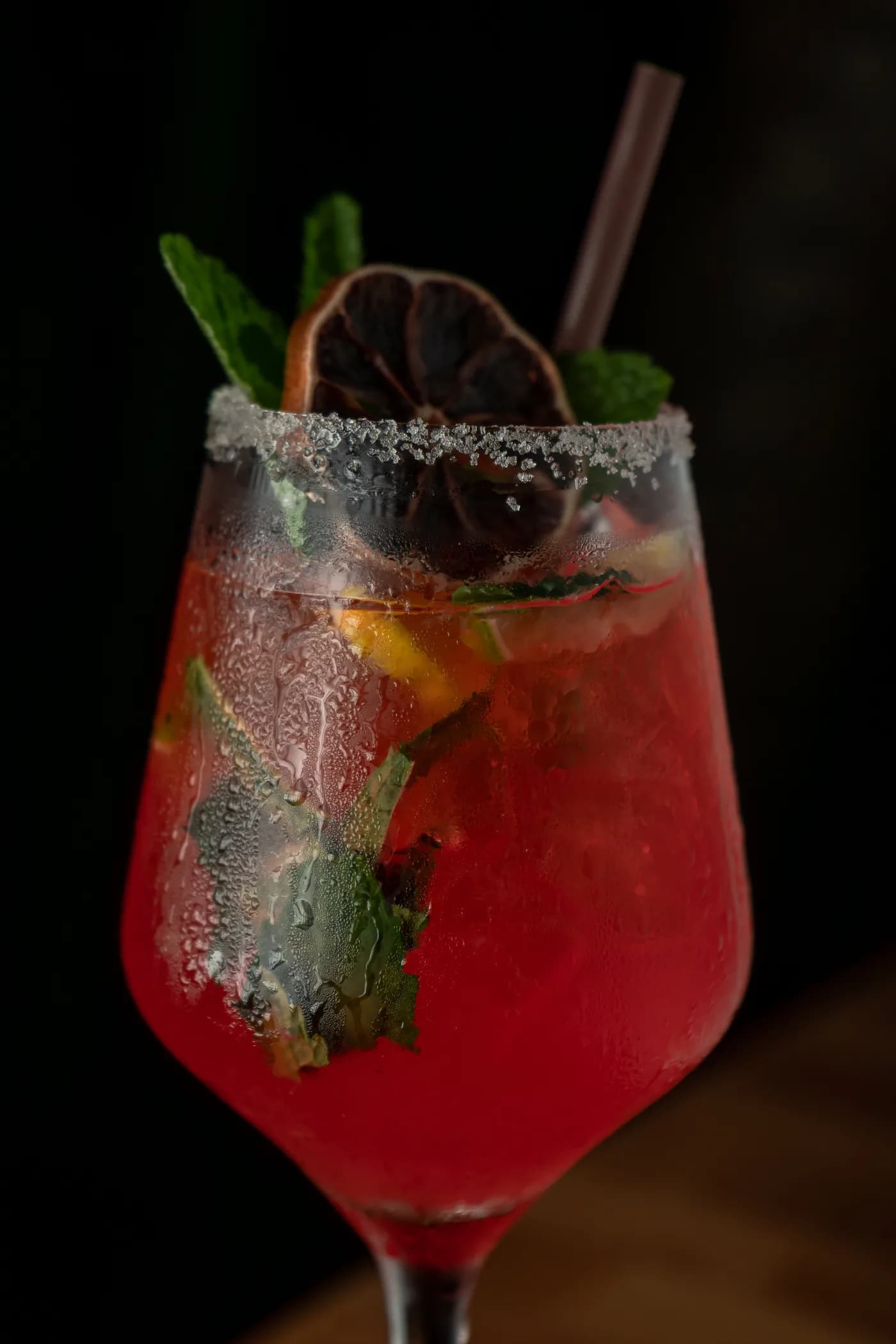 A red spritz with mint and a dried-citrus wheel