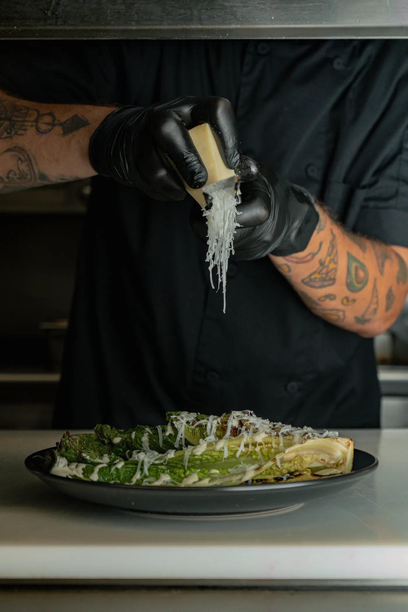 Chef grating cheese over the plate