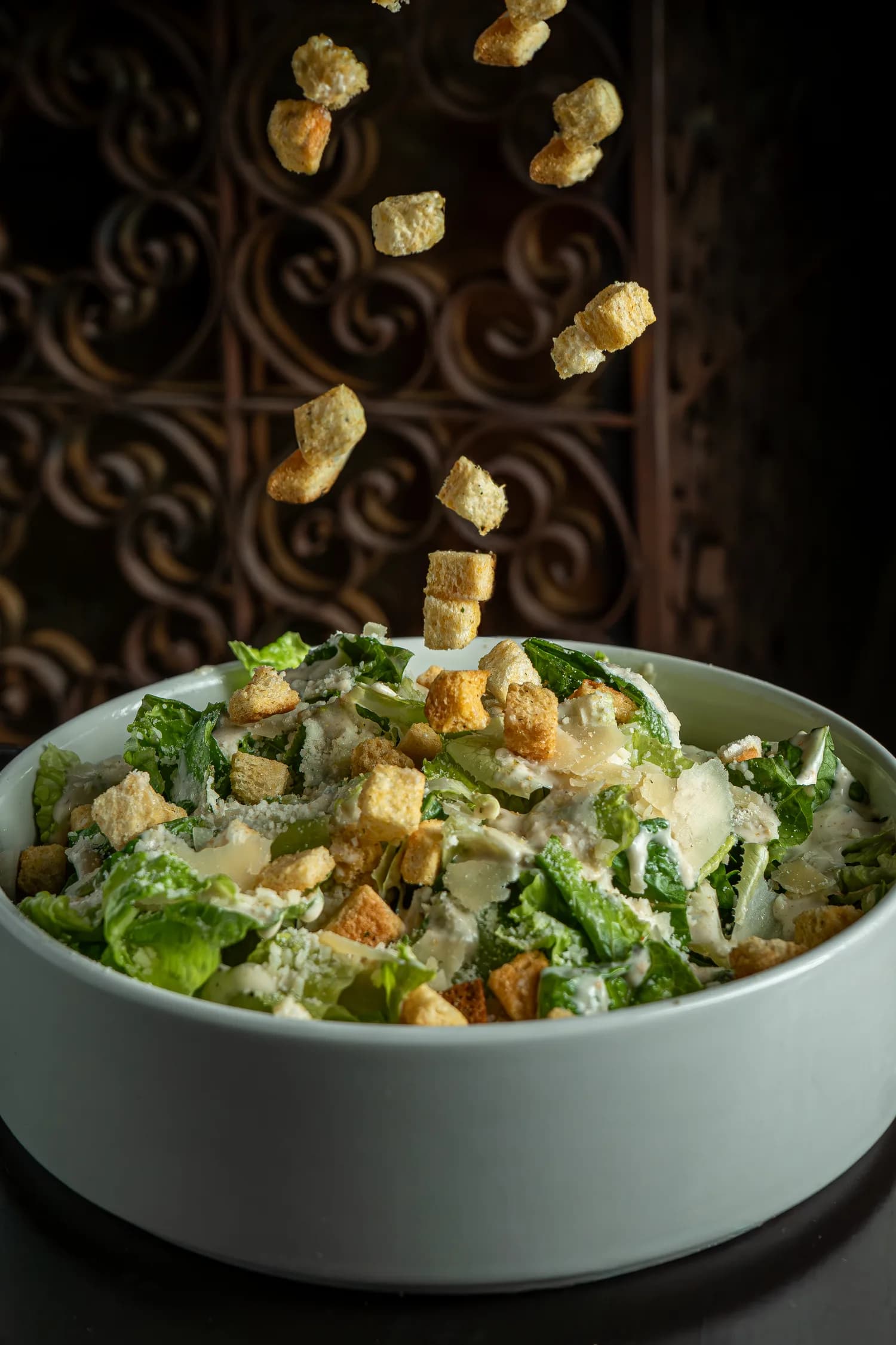 Croutons falling into a caesar salad