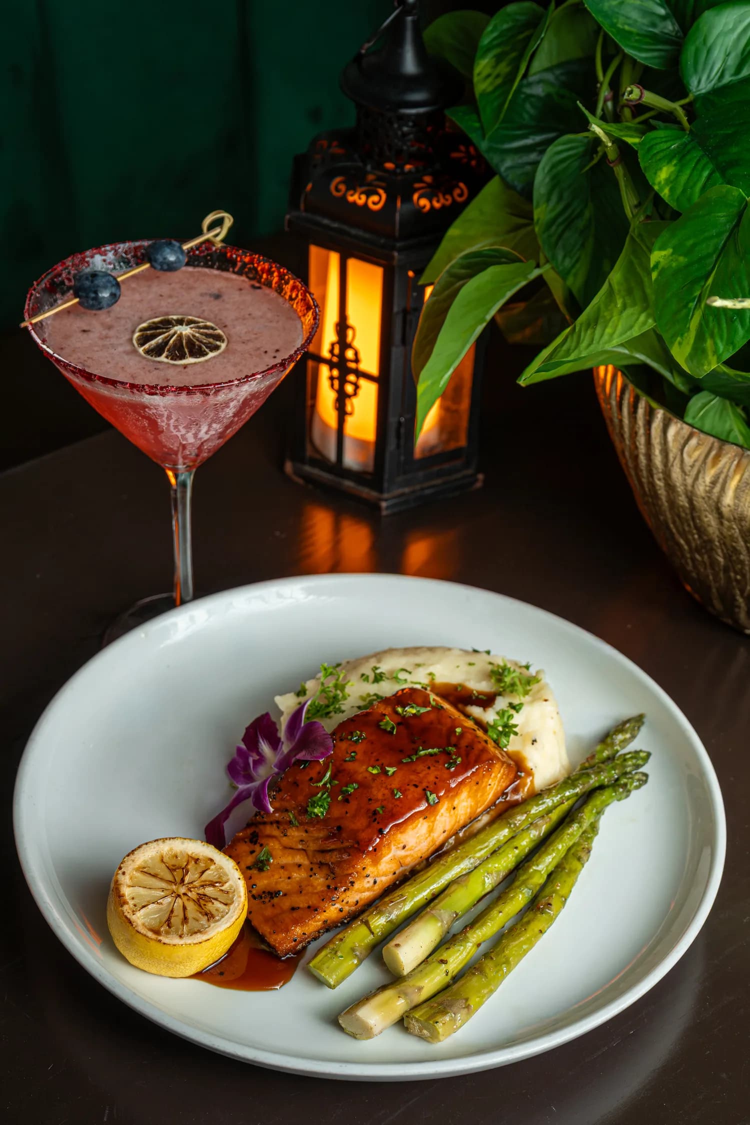 Glazed salmon with asparagus beside a red martini