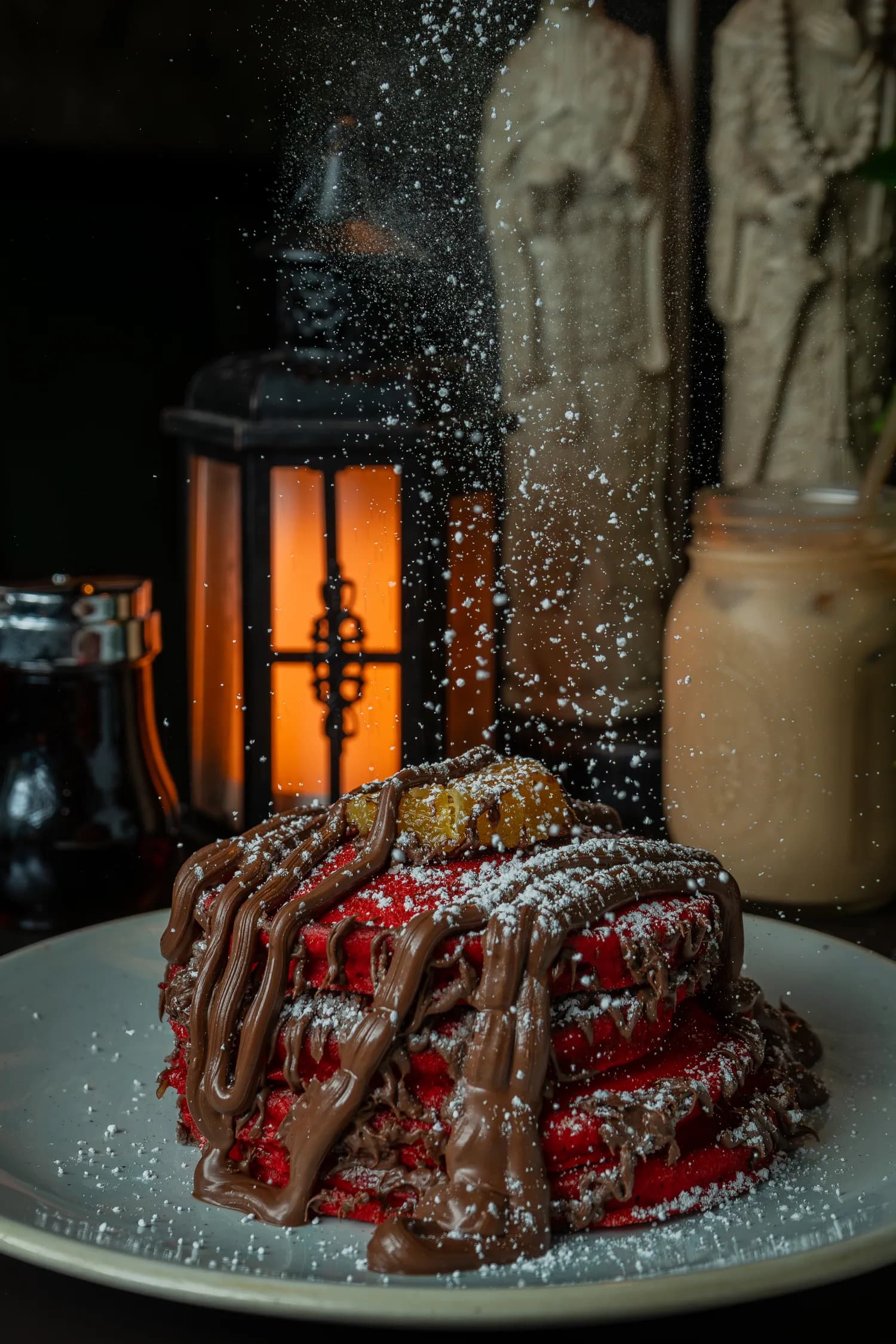 Sugar dusted over a red-velvet dish with chocolate drizzle
