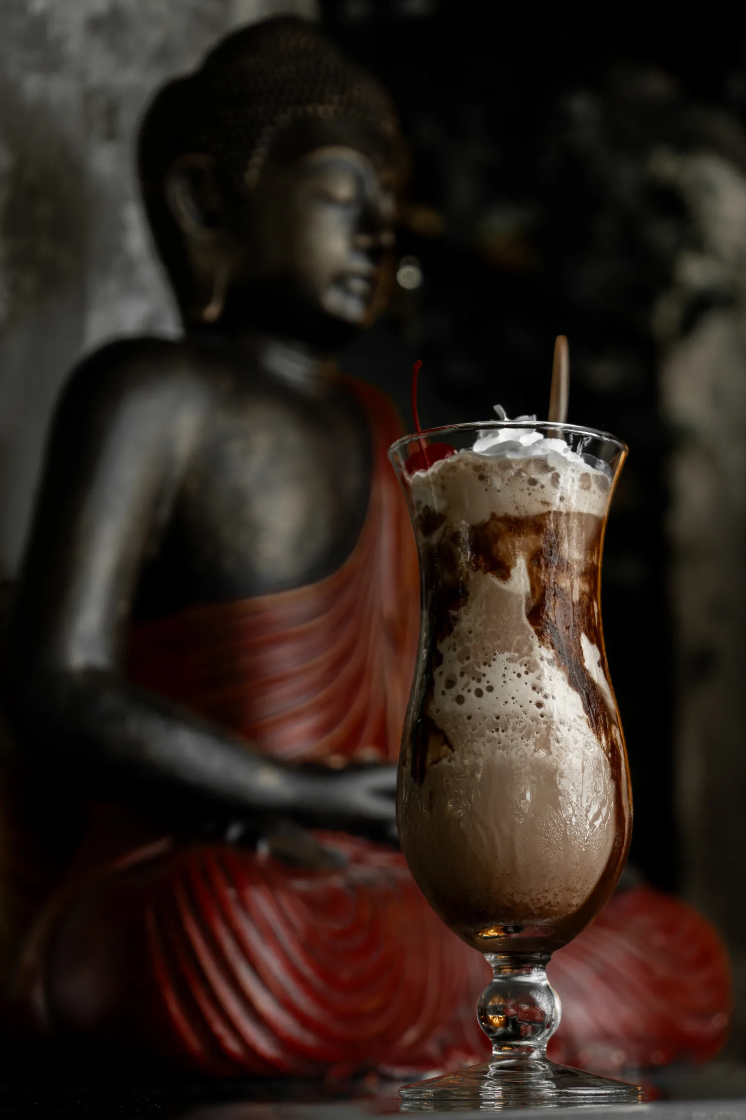 A chocolate mudslide cocktail before a Buddha statue