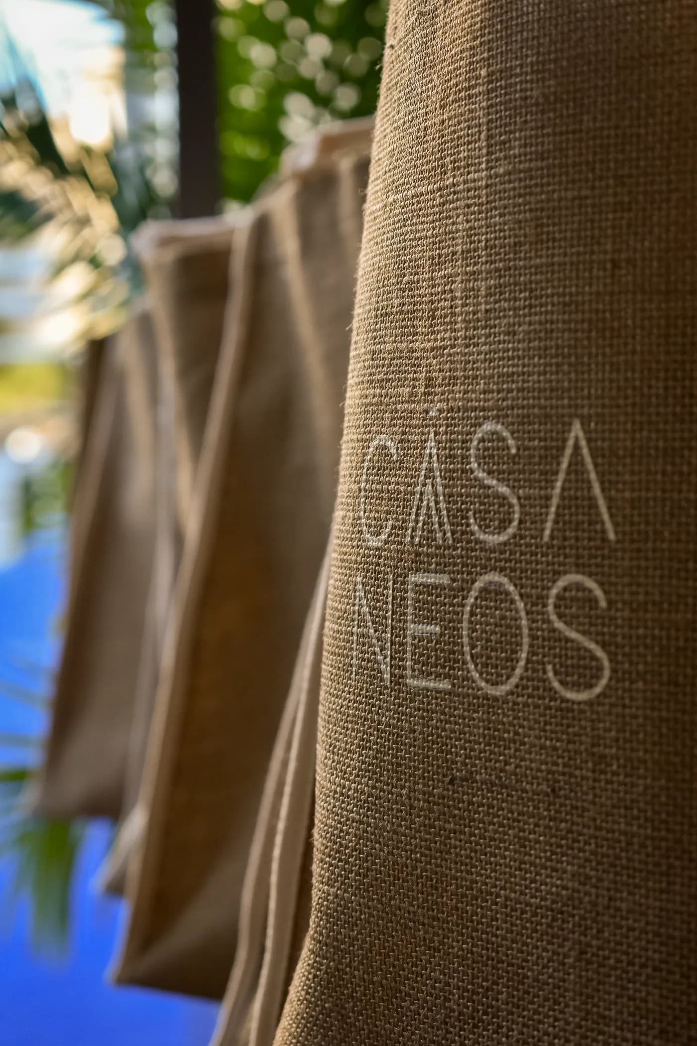 A Casa Neos tote hung on the court fence